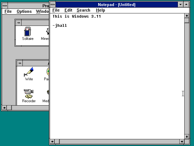 Windows 3.11 showing the Program Manager and Notepad editor