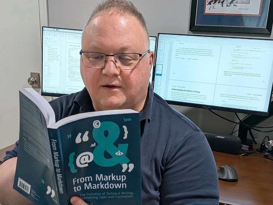 a man reading a book at a desk