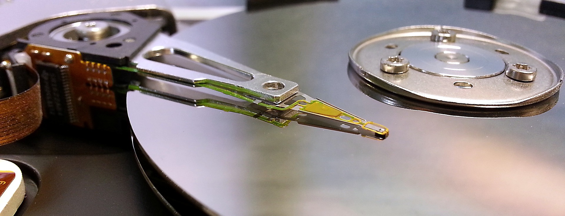 Wide picture of an open 5-inch hard drive showing the disks and the read / wriute heads.